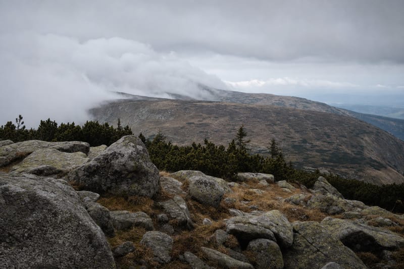 Skalisty granitowy grzbiet Karkonoszy z niską chmurą nad przełęczą